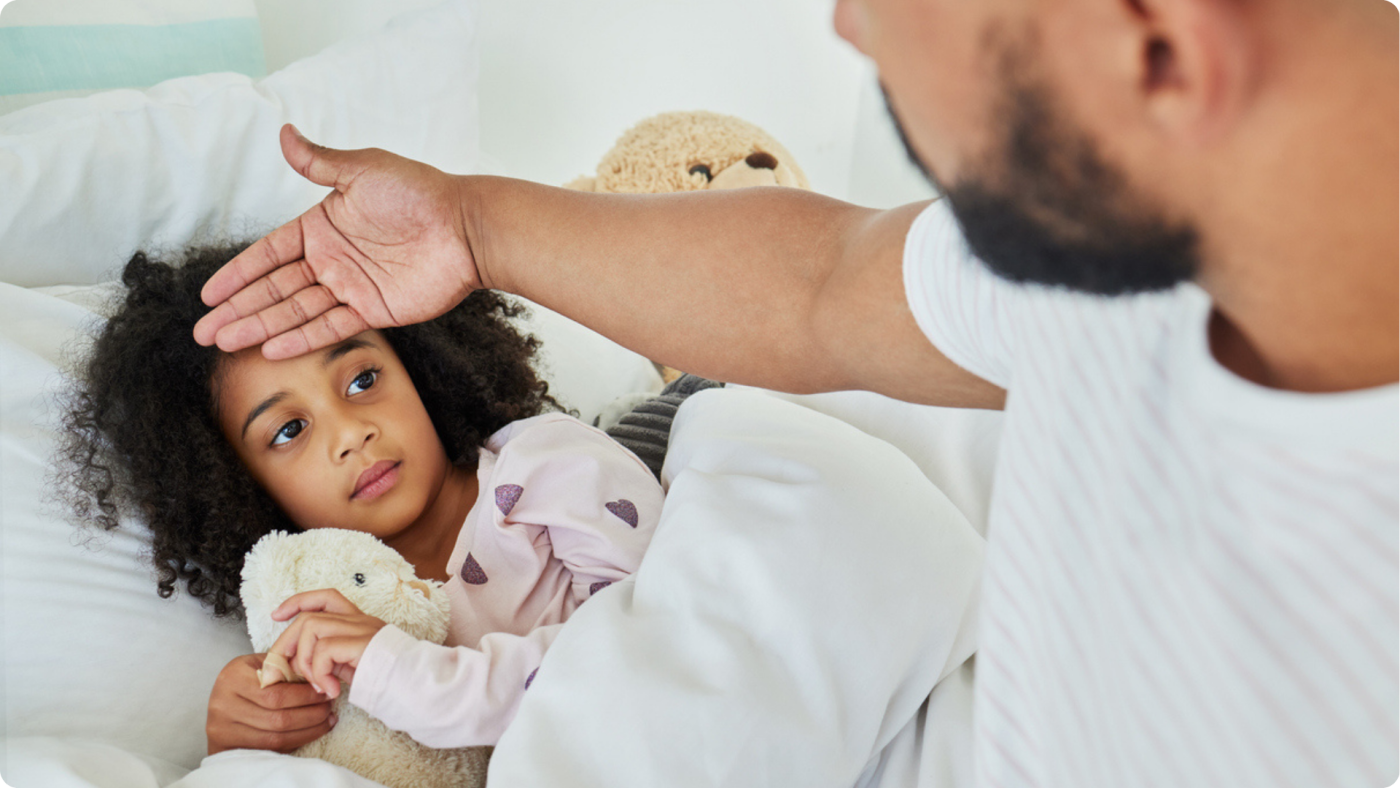 Is My Child Well Enough for Nursery? A father checking his daughters temperature in bed