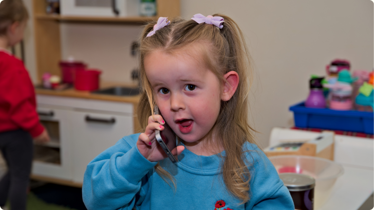 A little girl on a fake phone