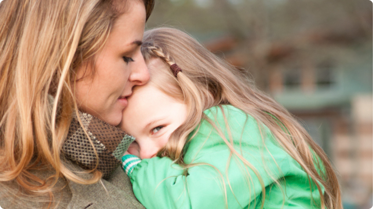 Shy Toddler cuddling into mums shoulder
