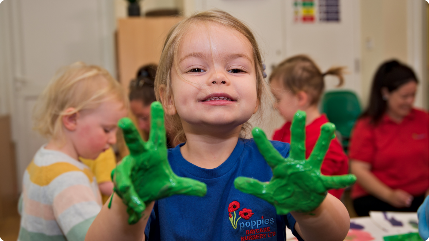 The 4 Types of Play in Child Development shown by a little girl playing with green paint