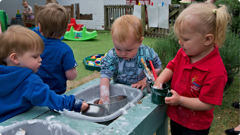 four toddlers participating in Cooperative Play which is one of the 4 Types of Play in Child Development
