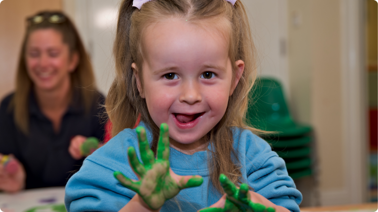 Independent Play for Toddlers shown by a toddler wiht paint all over their hands