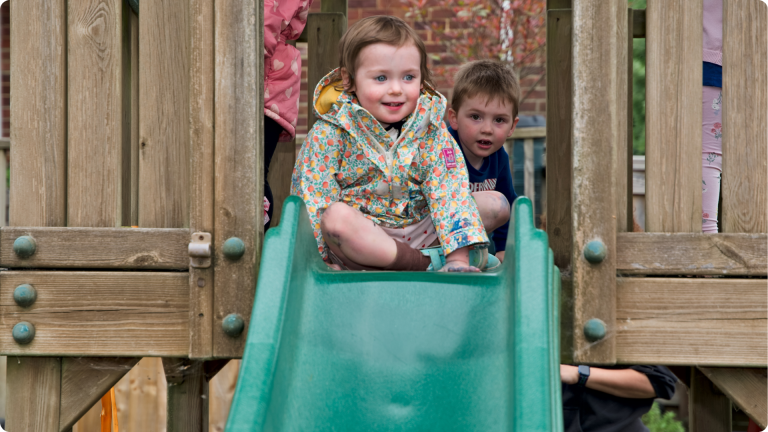 Independent Play for Toddlers shown by a toddler on a slide