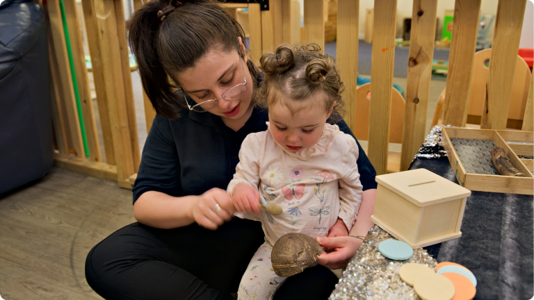 What Do They Teach in Nursery shown by a Poppies team member teaching a baby about sound