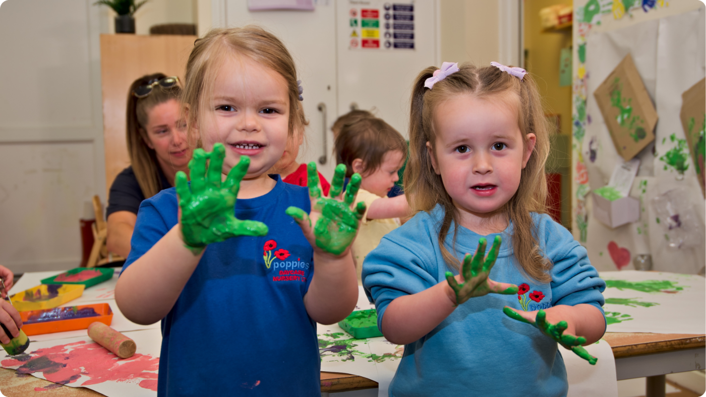 15 Hours Free Childcare shown by 2 toddlers playing with paint