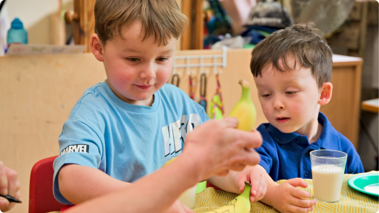 30 Hours Free Childcare can help you bring children like these 2 boys eating bananas into a nursery setting