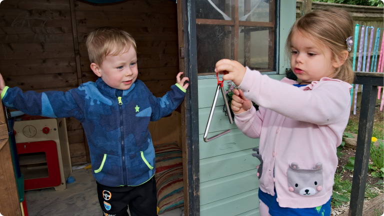 How to Build Confidence in a Sensitive Child shown by two children laying in a wendy house together
