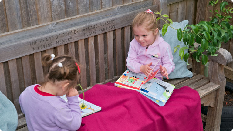 How to Build Confidence in a Sensitive Child shown by two children reading books together on a wooden bench 