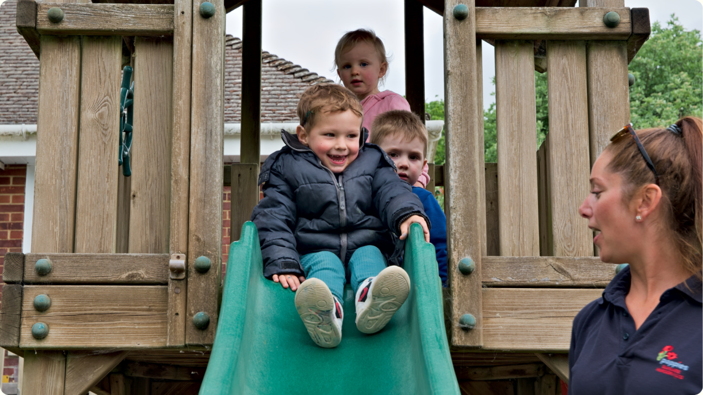 How to Build Confidence in Children shown by a child excited to go down the slde